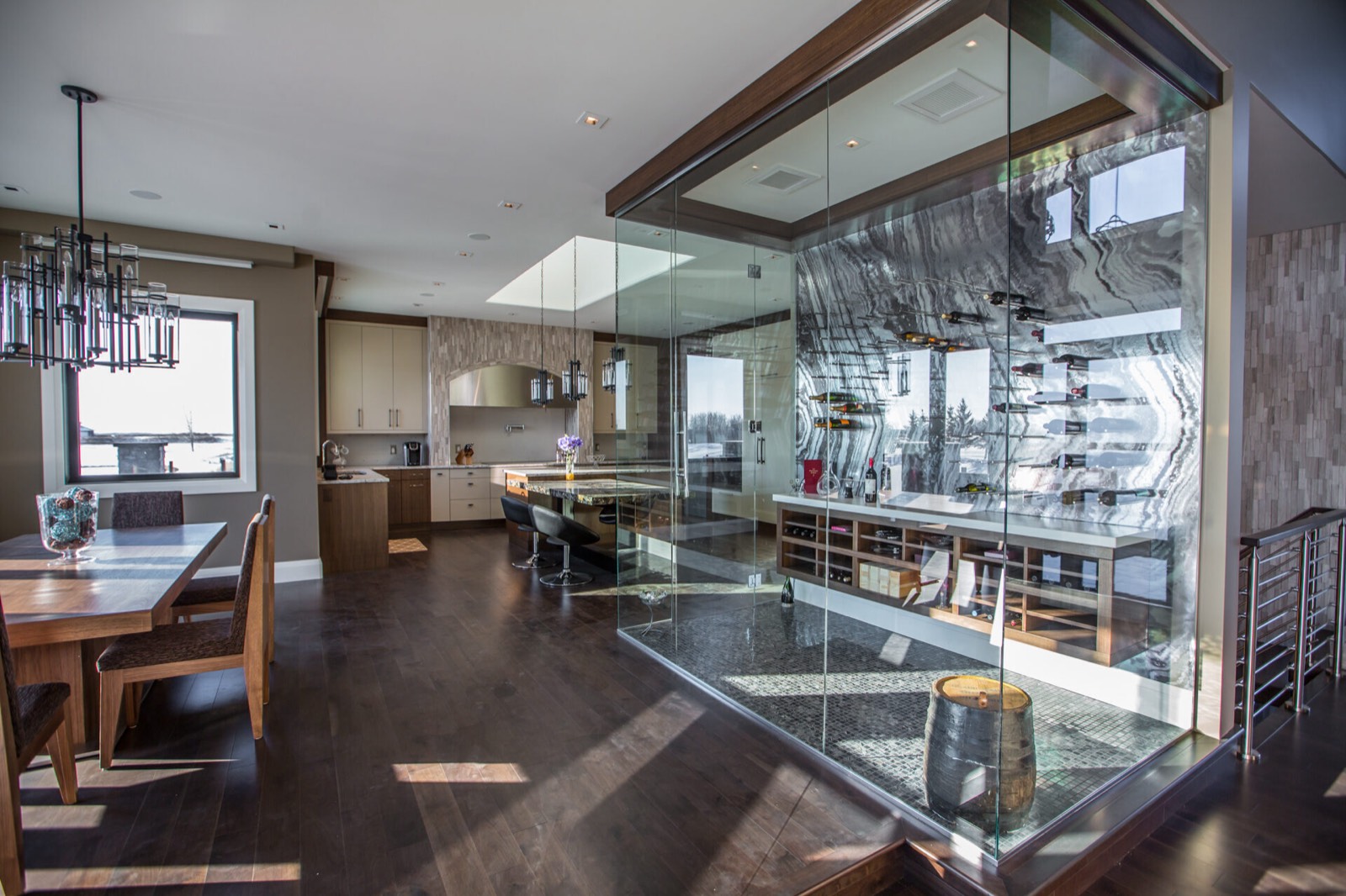 Open-concept kitchen and dining room with a glass-enclosed wine room in a Decora custom home