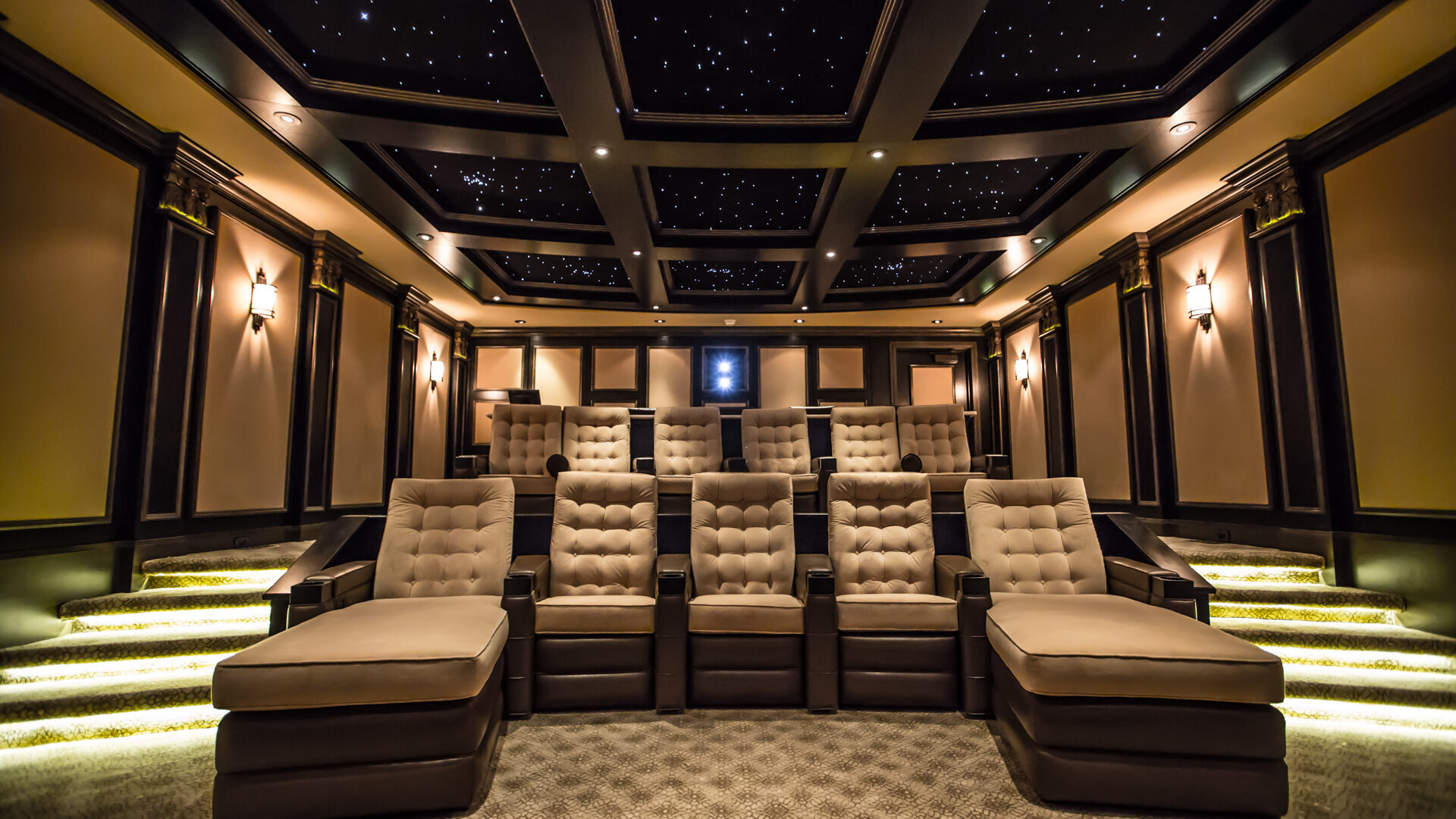 Custom home theatre with tiered leather recliners and a coffered, starlit ceiling