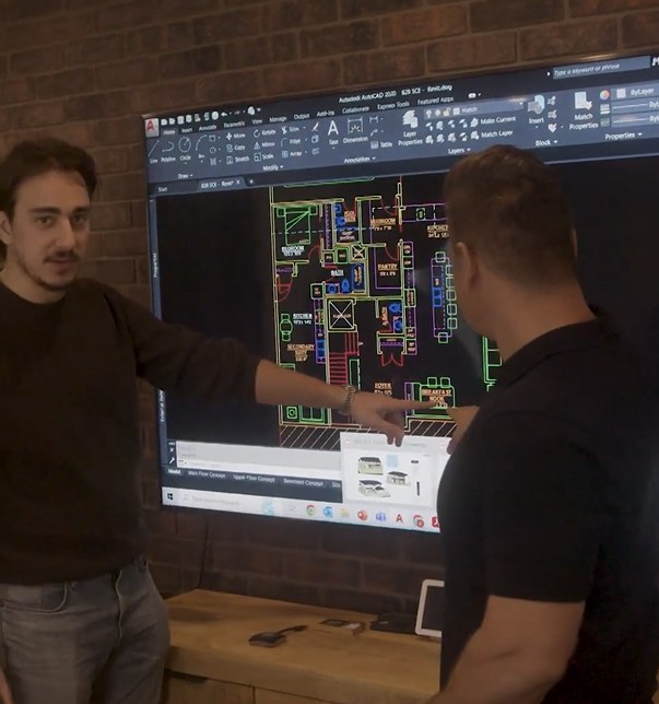 Dustin Grenier reviewing plans on screen with a colleague