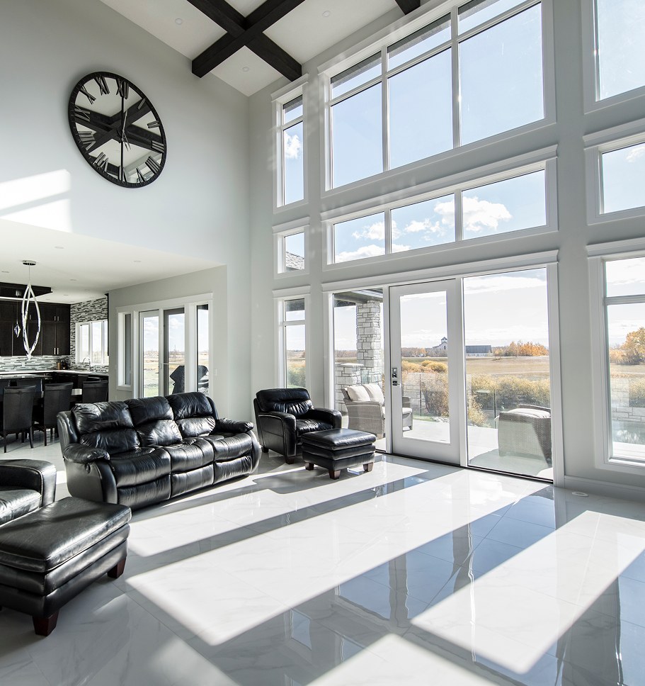 Double-height great room with floor-to-ceiling windows and leather seating