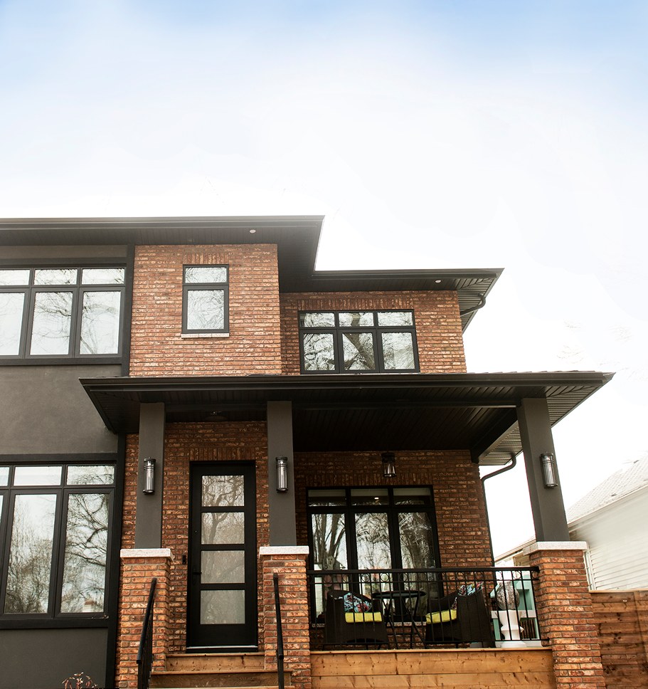 Two-storey Decora home with brick and dark trim and a covered front porch