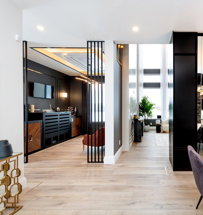 Hallway with a dark wood wall panel, wine storage and a view to the dining room