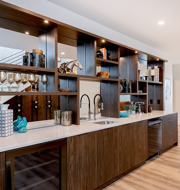 Built-in bar with open shelving, a wine fridge and a wood-panelled base
